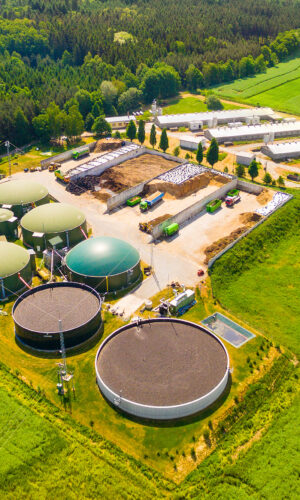 Aerial view over biogas plant and farm in green fields. Renewabl Aerial view over biogas plant and farm in green fields. Renewabl